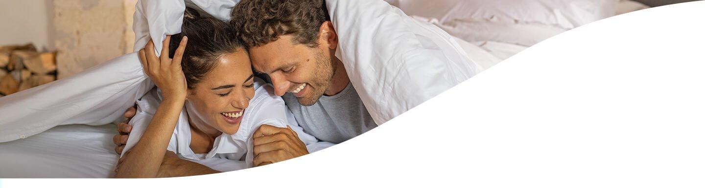 Couple smiling on Tempur mattress